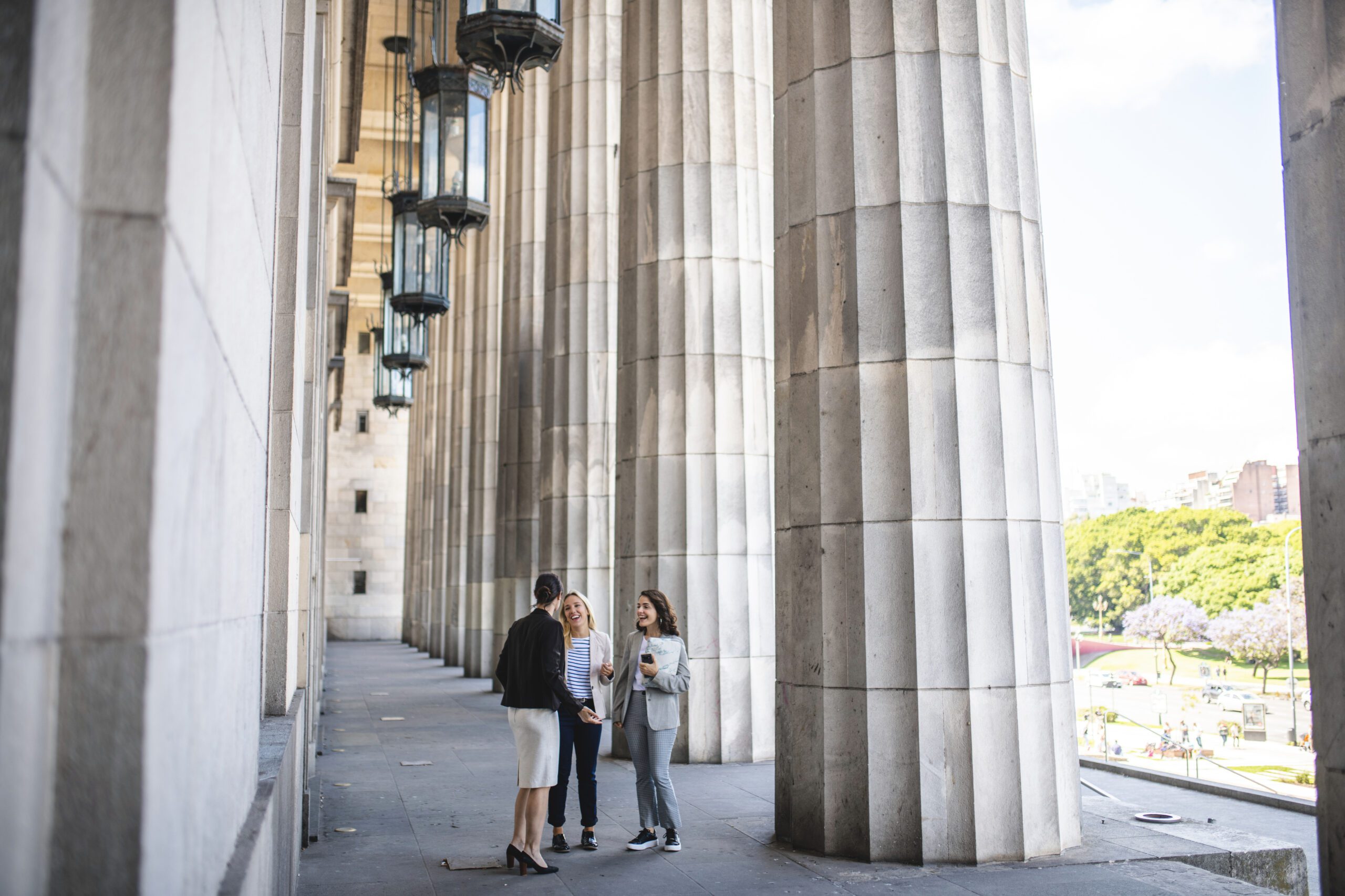 Law school admissions timeline Young female law school students standing in front of entrance to Neo-Classical university building and talking.