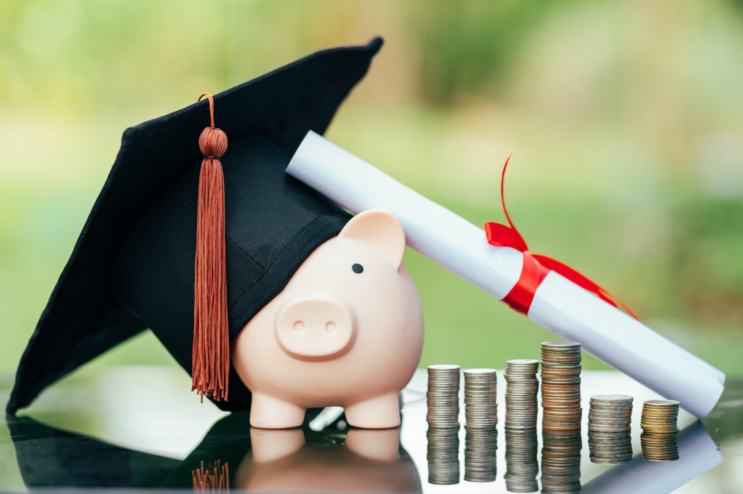 Law Schools With Full-Ride Scholarships piggy bank With Graduation Cap on black glass floor,Money saving concept.