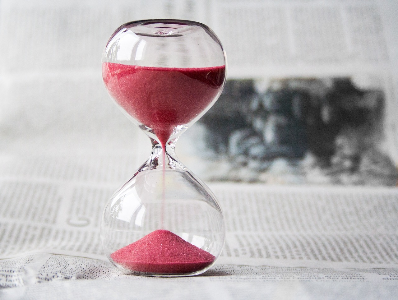 Clear hourglass with pink sand falling. LSAT time strategies