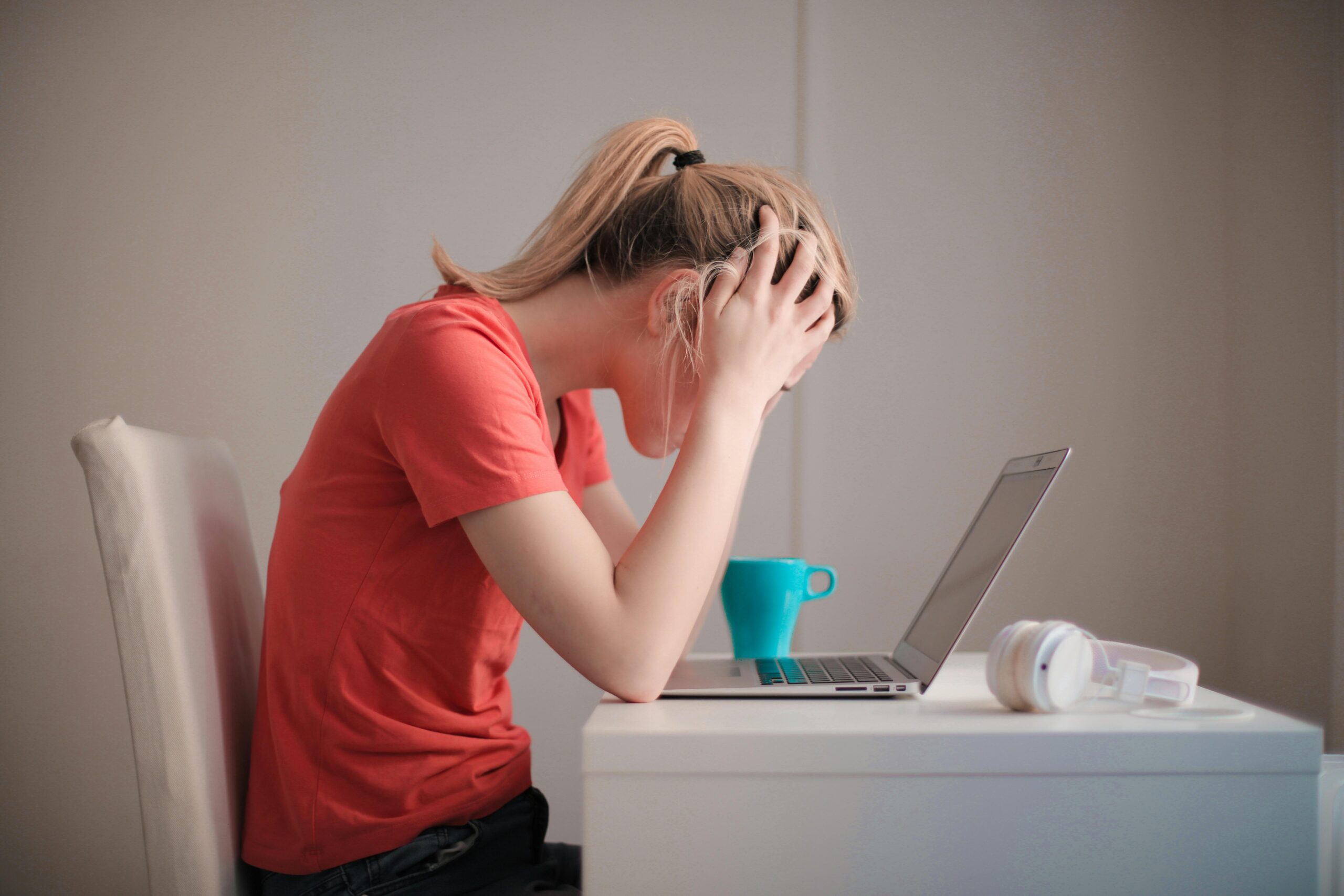 Blonde woman sitting in front of laptop stressed about getting back on MCAT timeline