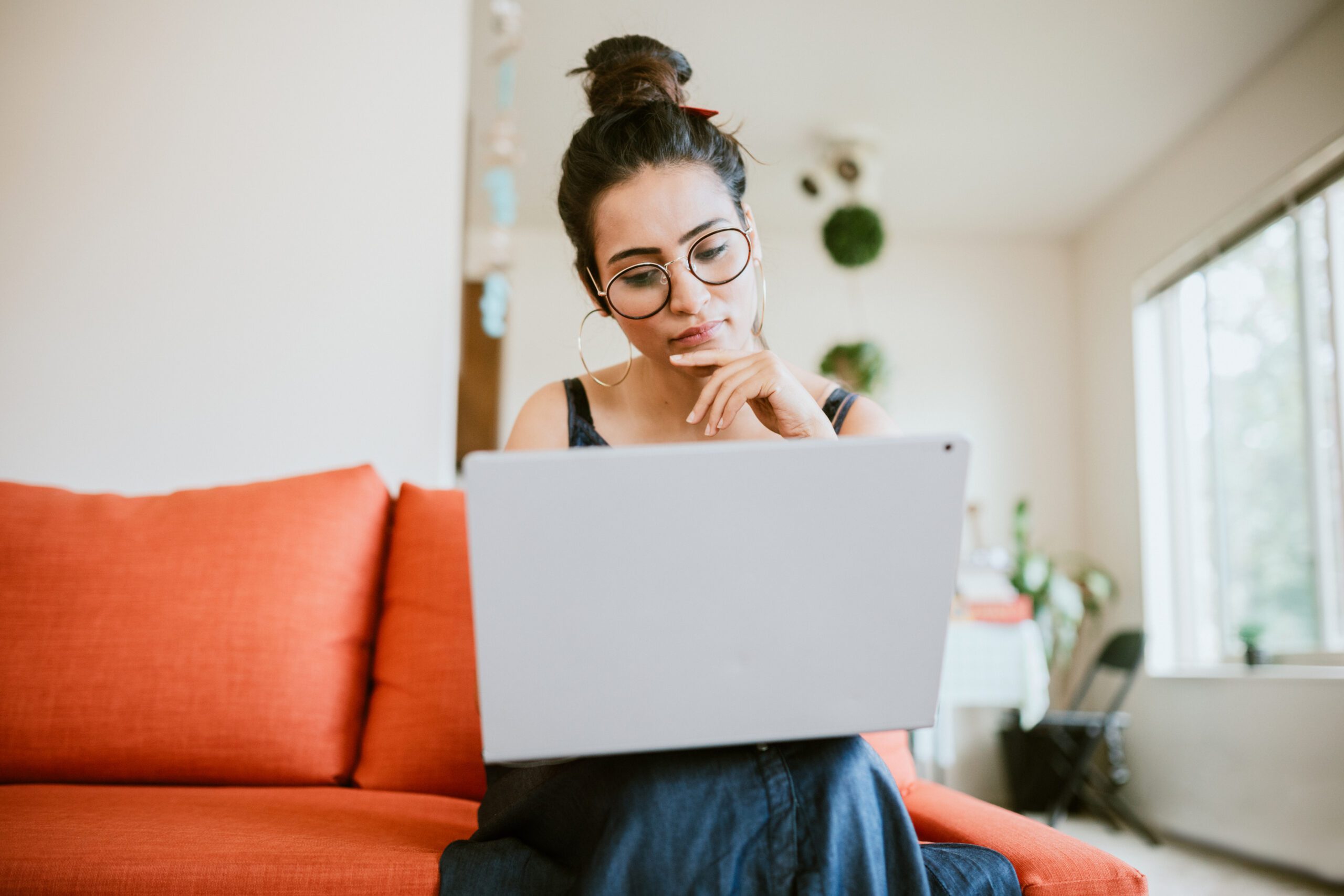 An Indian American woman works on a design project in the comfort of her apartment living room. MCAT test taking skills and myths