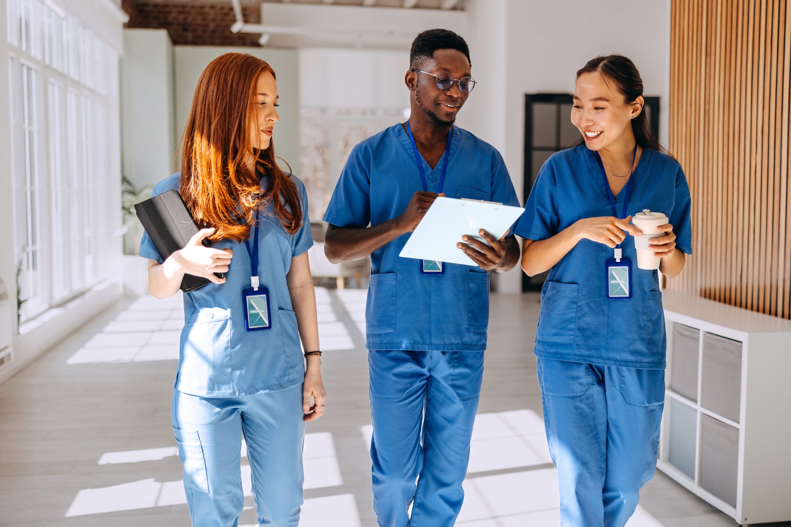 Jobs for premed students Young healthcare colleagues walking and talking at hospital corridor