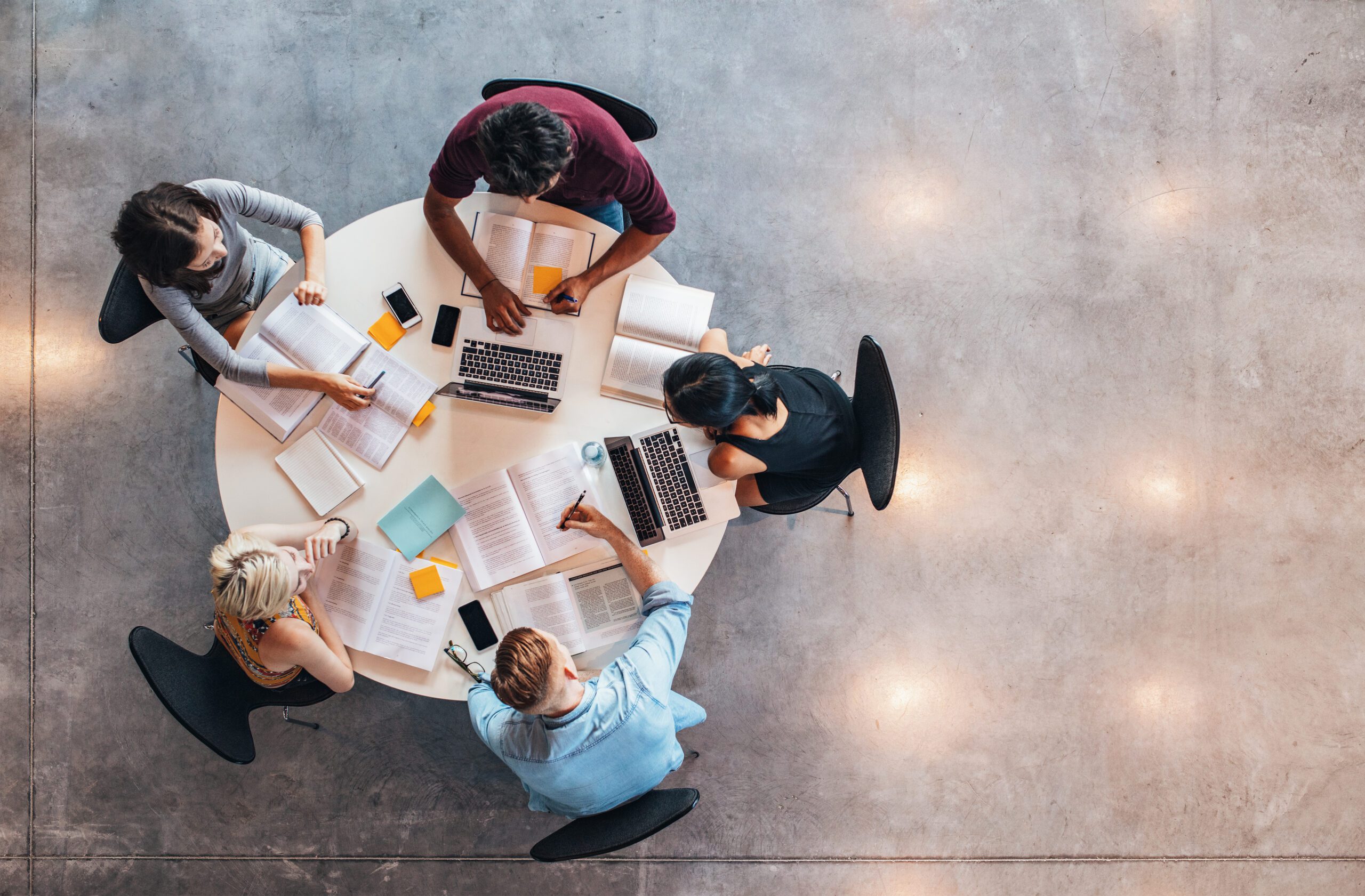 What do law schools look for? Top view of group of students sitting together at table. University students doing group study.